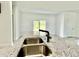 Close-up of a granite island with a modern sink, faucet, and open-concept living space in the background at 2645 Sw 155Th Ln, Ocala, FL 34473