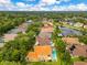 Aerial view of community and home with private pool, lush landscaping, and nearby pond at 283 Lakay Pl, Longwood, FL 32779
