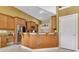 Open kitchen with breakfast bar, stainless refrigerator, granite counters, and wood cabinets at 283 Lakay Pl, Longwood, FL 32779