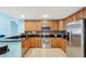 Well-lit kitchen features stainless steel appliances, wood cabinets, granite countertops, and tile flooring at 3038 Golden Rock Dr, Orlando, FL 32818