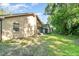 Grassy back yard and exterior view of tan home at 316 Dornoch Ct, Winter Springs, FL 32708
