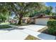 Brick home with mature trees, long driveway, two-car garage, and attractive landscaping at 316 Dornoch Ct, Winter Springs, FL 32708