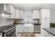 Modern kitchen featuring white cabinetry, stainless steel appliances, and a stylish backsplash at 316 Dornoch Ct, Winter Springs, FL 32708