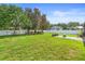 This spacious backyard offers a stone patio with a fire pit, surrounded by lush greenery and a white fence at 3551 Statham Dr, Apopka, FL 32712