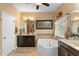 Bathroom featuring a corner tub, dual vanities, neutral tones, and bright lighting for a clean aesthetic at 3551 Statham Dr, Apopka, FL 32712