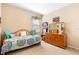Neutral bedroom features a daybed, natural light, and a charming cozy atmosphere and a wood dresser at 3551 Statham Dr, Apopka, FL 32712