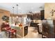 Open kitchen featuring an island with seating, dark cabinetry, and stainless steel appliances at 3551 Statham Dr, Apopka, FL 32712
