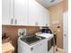 Functional laundry room with white cabinets and modern washer and dryer at 3551 Statham Dr, Apopka, FL 32712
