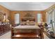 Spacious main bedroom with warm lighting, a decorative headboard, dresser and exercise equipment at 3551 Statham Dr, Apopka, FL 32712