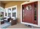 Inviting front porch features cozy seating, a wreath on the red door, and ample natural light at 3551 Statham Dr, Apopka, FL 32712