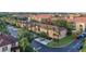 Community aerial view with red tile roofs, palm trees, landscaping, and street parking spaces at 412 Verona Ave, Davenport, FL 33897