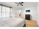 Bright bedroom with a view to an open bathroom entrance, a ceiling fan, and a TV mounted to the wall at 412 Verona Ave, Davenport, FL 33897