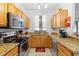 Bright kitchen featuring stainless steel appliances, stone countertops, and wood cabinets at 412 Verona Ave, Davenport, FL 33897