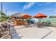 Outdoor seating area with tiki hut, chairs, tables, and a 
