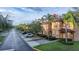 Street view of townhomes with well-maintained lawns, trees, landscaping and plenty of parking spaces at 412 Verona Ave, Davenport, FL 33897