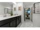 Stylish bathroom boasts double vanity, modern fixtures, and shower with glass door, complemented by marble-look tile at 4161 Paragraph Dr, Kissimmee, FL 34746