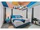 Modern bedroom with colorful ceiling art, plush bedding, and stylish decor offers a unique and inviting space at 4161 Paragraph Dr, Kissimmee, FL 34746