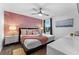Relax in this stylish bedroom featuring pink geometric wall decor, soft lighting, and modern furnishings at 4161 Paragraph Dr, Kissimmee, FL 34746