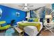 Bright bedroom showcasing a unique tropical wall, plush bedding, modern furniture, and ample natural light at 4161 Paragraph Dr, Kissimmee, FL 34746