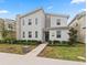 Modern two-story home features neutral colors, large windows, and a well-manicured lawn with mature landscaping at 4161 Paragraph Dr, Kissimmee, FL 34746