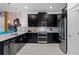 A modern kitchen features black cabinets, stainless appliances, a tile backsplash and plenty of countertop space at 4161 Paragraph Dr, Kissimmee, FL 34746