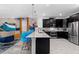 Modern kitchen features stainless steel appliances, a quartz countertop island, and ample cabinet space at 4161 Paragraph Dr, Kissimmee, FL 34746