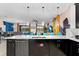 Modern kitchen with black cabinets, pendant lighting, and an open floor plan to the dining and living spaces at 4161 Paragraph Dr, Kissimmee, FL 34746