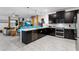 This kitchen features black cabinets, stainless appliances, a quartz island and an open layout to the living area at 4161 Paragraph Dr, Kissimmee, FL 34746