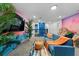 Upstairs living area offering a comfy blue couch, large TV, cool tropical-themed decor, and a relaxing ambiance at 4161 Paragraph Dr, Kissimmee, FL 34746