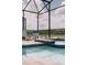 Sparkling pool with an attached hot tub and a view to an expansive lake in the background under a screened enclosure at 4161 Paragraph Dr, Kissimmee, FL 34746