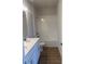 Bathroom with double vanity, quartz countertop, shower over tub and wood-look tile flooring at 446 Scotsmans Pl, Debary, FL 32713