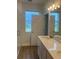 Bright bathroom featuring a modern vanity with quartz countertop and wood-look tile flooring at 446 Scotsmans Pl, Debary, FL 32713