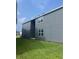 Exterior side view of a modern gray home with well-maintained lawn at 446 Scotsmans Pl, Debary, FL 32713