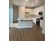 Modern kitchen features white cabinets, stainless steel appliances, an island with sink, and tile backsplash at 446 Scotsmans Pl, Debary, FL 32713
