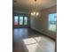Bright and airy living room boasts wood-look tile flooring, recessed lighting, and a modern chandelier at 446 Scotsmans Pl, Debary, FL 32713