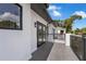 Exterior balcony view featuring dark gray tiled flooring, sleek black railings, and stucco walls at 523 W Princeton St # 1, Orlando, FL 32804