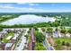 Wide aerial shot of residential complex near a lake, featuring tree-lined streets, parking, and exterior views of buildings at 5545 Devonbriar Way # 206, Orlando, FL 32822