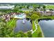 An aerial view showcasing a community pool near a pond surrounded by lush greenery and trees at 5545 Devonbriar Way # 206, Orlando, FL 32822
