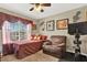 Cozy bedroom with a ceiling fan, sunny window, and seating area with an exercise bike at 5545 Devonbriar Way # 206, Orlando, FL 32822