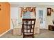 Bright dining area with seating for four, featuring neutral chairs, glass table, and decorative window treatments at 5545 Devonbriar Way # 206, Orlando, FL 32822