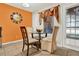 Bright eat-in kitchen area with seating for four, neutral chairs, a glass table, and decorative window treatments and clock at 5545 Devonbriar Way # 206, Orlando, FL 32822
