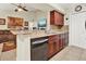 Open kitchen layout with breakfast bar and dark wood cabinets, seamlessly connected to the living area at 5545 Devonbriar Way # 206, Orlando, FL 32822