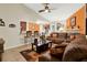 Spacious living room with tile floors, opening to kitchen bar with comfortable brown leather sofa set at 5545 Devonbriar Way # 206, Orlando, FL 32822