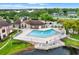 Overhead view of community pool area with a uniquely shaped pool with lounge chairs, trees, and nice landscaping at 5545 Devonbriar Way # 206, Orlando, FL 32822