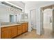 Bright bathroom boasts wood cabinets, dual sinks, and large mirror with an arched doorway at 604 Cheviot Ct, Apopka, FL 32712