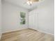 An empty bedroom with light wood laminate flooring, a window, and a double door closet at 604 Cheviot Ct, Apopka, FL 32712