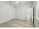 Empty bedroom with light wood floors, white walls, a closet and an entrance to another room at 604 Cheviot Ct, Apopka, FL 32712