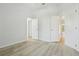Empty bedroom with light wood floors, white walls, and three doors at 604 Cheviot Ct, Apopka, FL 32712