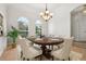 Elegant dining room with a wooden table set for six, lit by natural light from three windows at 604 Cheviot Ct, Apopka, FL 32712