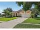 Well-maintained single-story home with lush landscaping and a two-car garage at 604 Cheviot Ct, Apopka, FL 32712